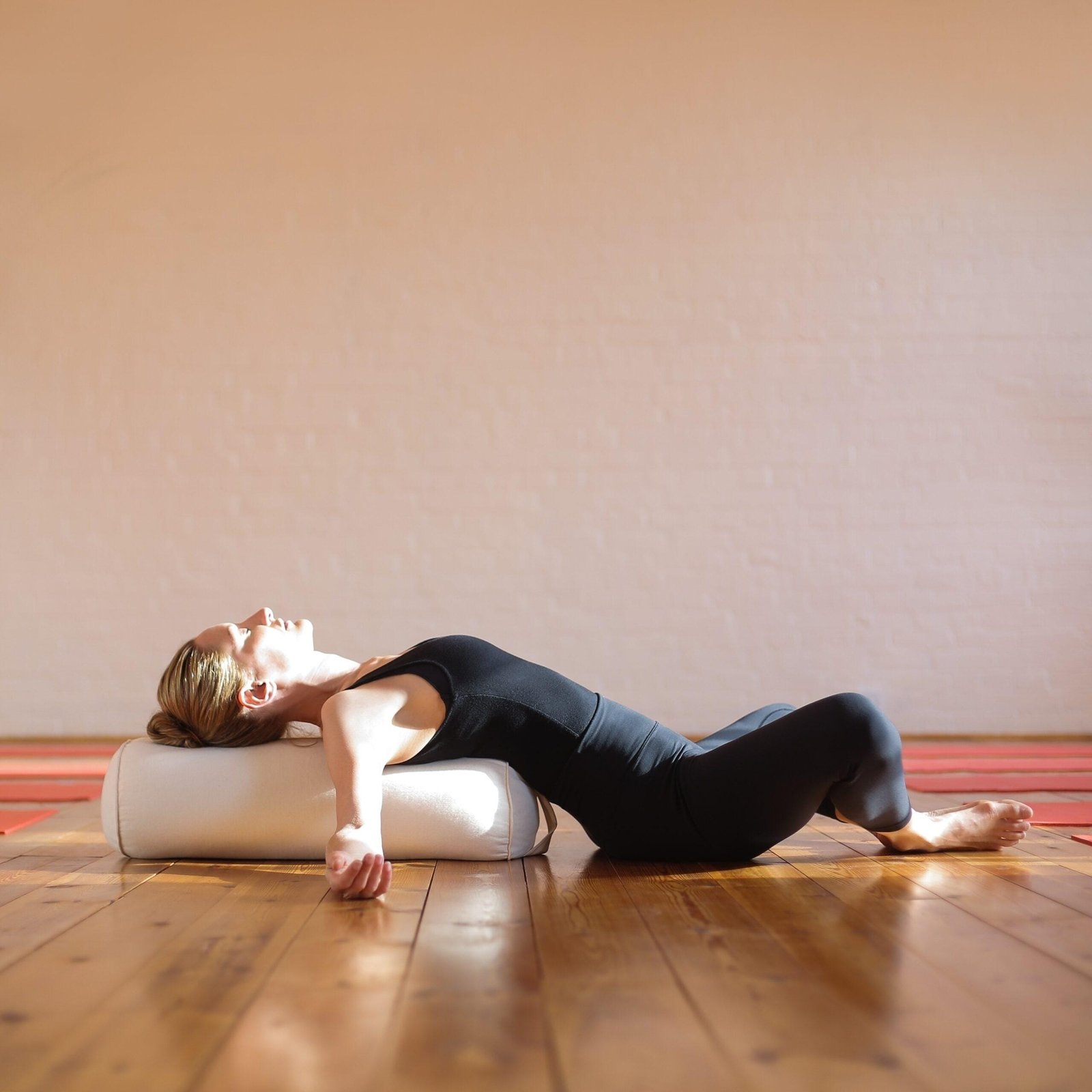 Blonde vrouw doet een liggende yoga houding