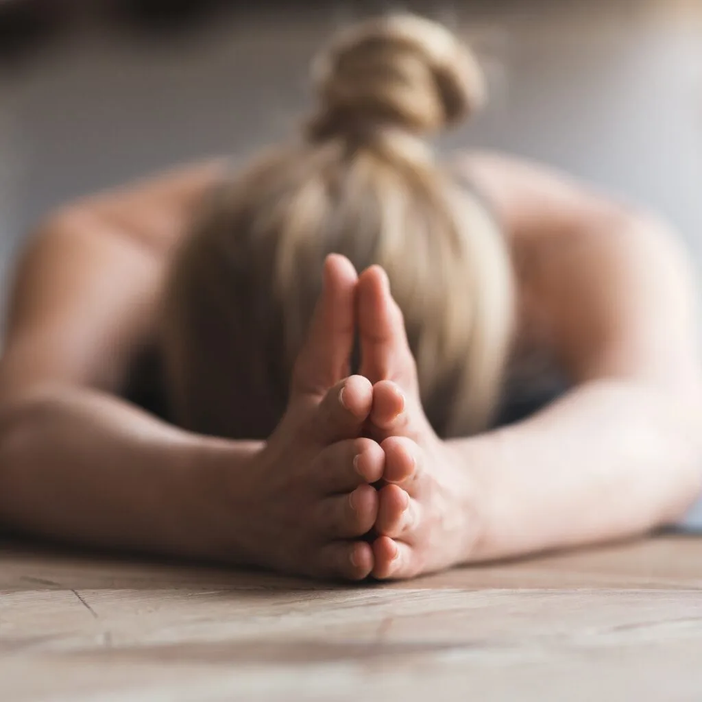 Vrouw doet een yoga nidra houding in een yogastudio
